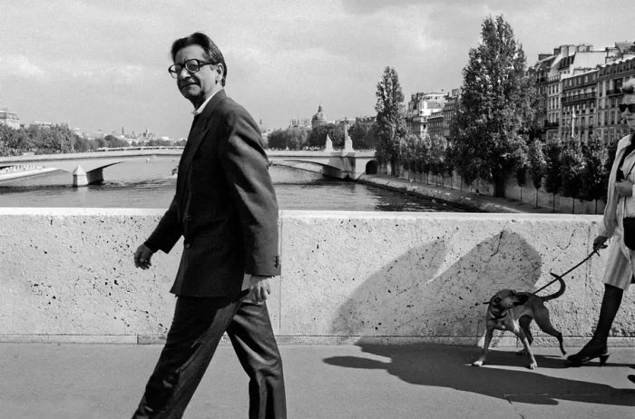 The author V.S. Naipaul is seen crossing a bridge in Paris.