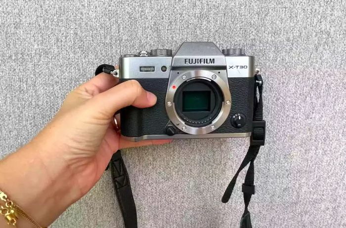 An individual grasping the Fujifilm X-T30 II