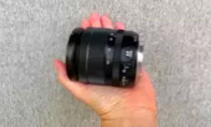 A person holding the lens of the Fujifilm X-T30 II