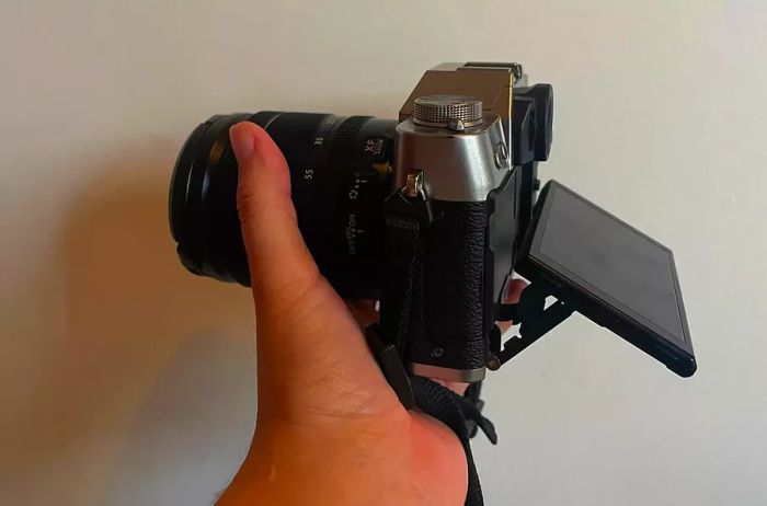 An individual grasping the Fujifilm X-T30 II with the screen angled outwards