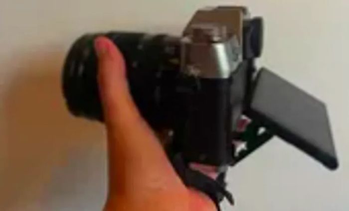 A person is holding the Fujifilm X-T30 II with the screen angled outward