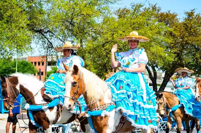 Women elegantly ride horseback during the parade.