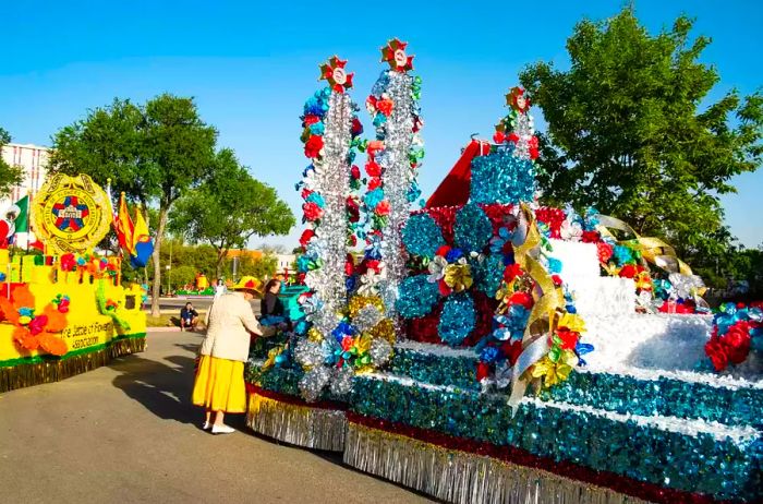 A woman in yellow meticulously inspects every detail of a float to ensure it's perfectly prepared for the parade.