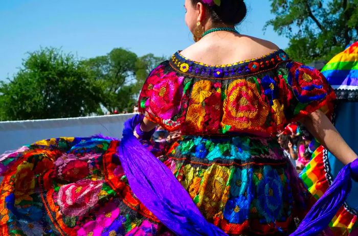 A close-up shot showcases the vibrant colors of a ballet folklorico dancer's dress.