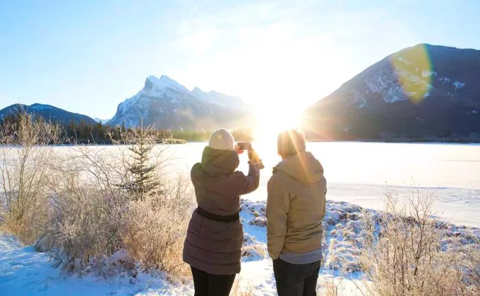 People capturing a snapshot of a frozen lake in winter