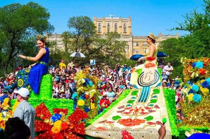 Two duchesses take their place on a float, navigating through large crowds as they pass by.