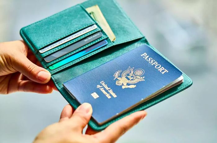 A pair of hands holding an open passport holder, showcasing the front cover of a passport