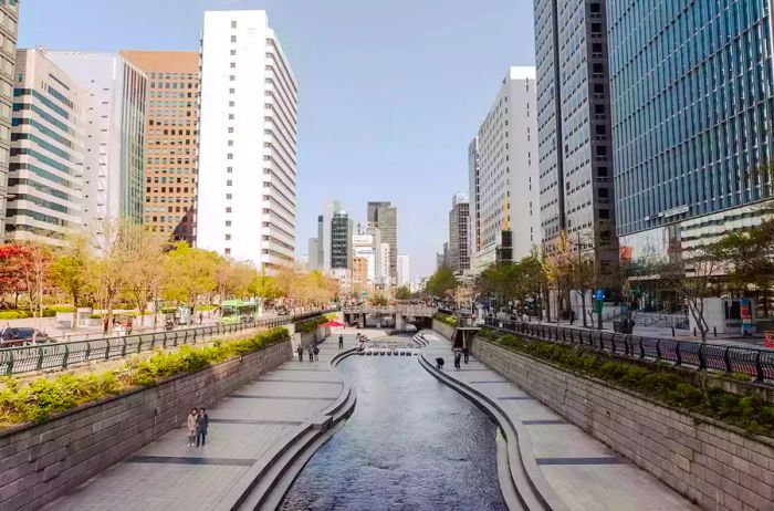 Individuals strolling along the riverside walkway in Seoul