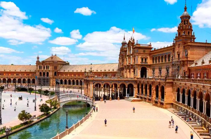 Daytime view of a plaza in Seville, Spain, bustling with people