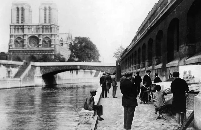 France, Paris: Artists painting by the Seine River with Notre Dame cathedral in the background, 1929