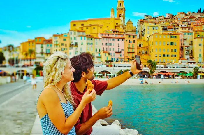 A couple enjoying ice cream and snapping a selfie in Europe.