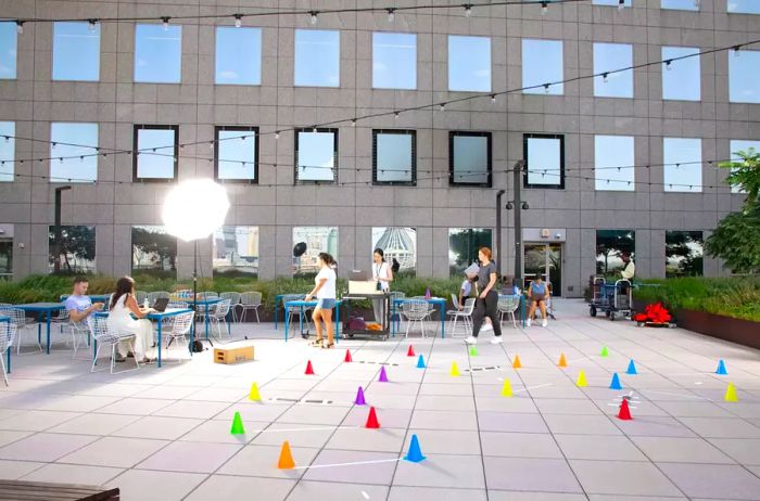 Individuals working on a patio surrounded by an obstacle course of colorful cones