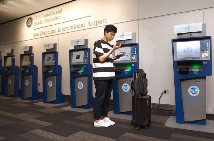 Kihyun Yoon checks in at the Global Entry computers located at U.S. Customs and Border Protection in San Francisco International Airport on Thursday, July 26, 2018.