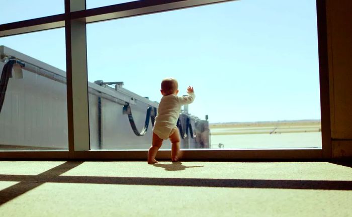 Infant looking out from an airport window