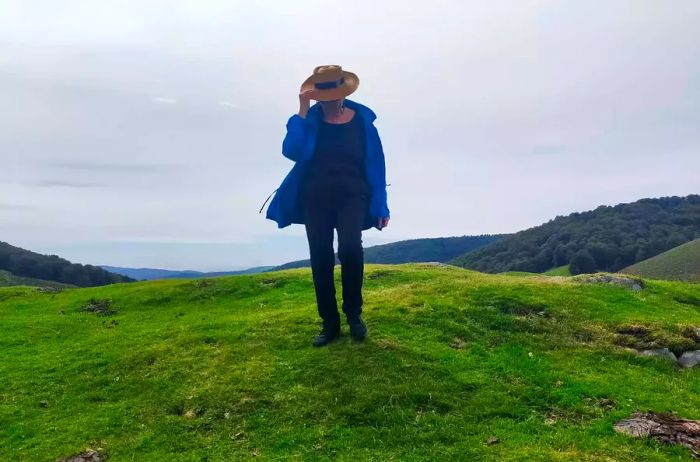 An older woman enjoying the lush green hills of Spain