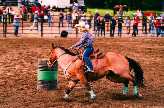 A woman participates in horseback riding during a rodeo