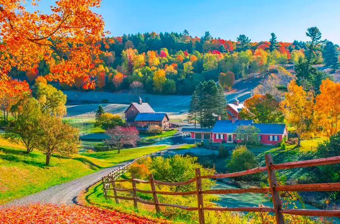 A picturesque view of early autumn foliage surrounding homes in the mountains of Woodstock, Vermont.