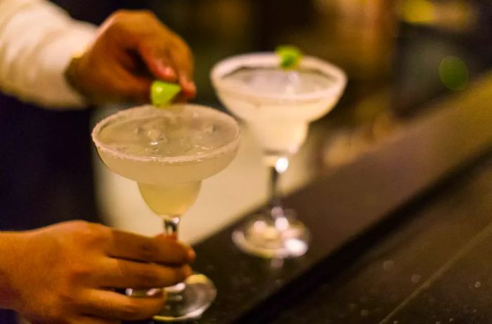 A bartender skillfully mixing margaritas