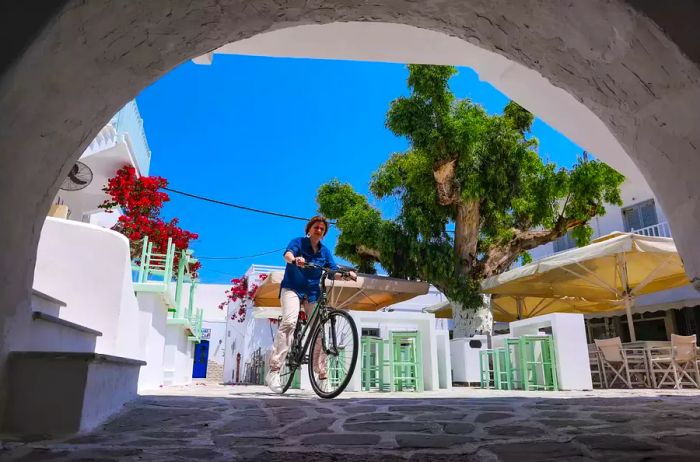 Explore the narrow alleys that wind around the old Venetian Castle, lined with traditional whitewashed houses adorned with trees and flowers in the charming town of Antiparos, located on Antiparos Island in the Cyclades, Aegean Sea, Greece.