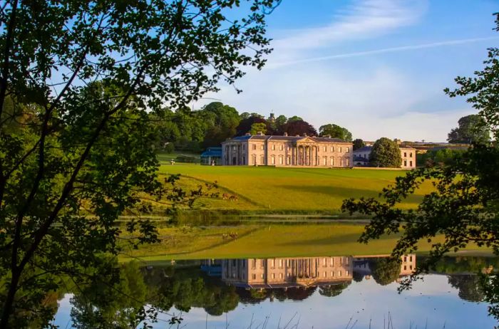 A view of the exterior of Ballyfin alongside the lake.