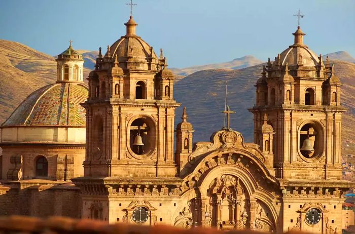 The twin towers and dome of the historic Iglesia de la Compania rise above the red rooftops of Cusco in Peru. This church, dating back to 1571, is built on the ruins of an ancient Inca Palace.