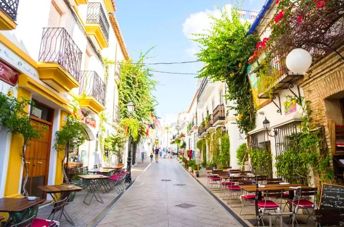 A street lined with tables in Marbella, Spain