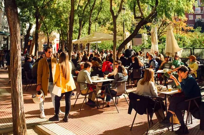 Patrons enjoying meals at outdoor cafes in Madrid, Spain