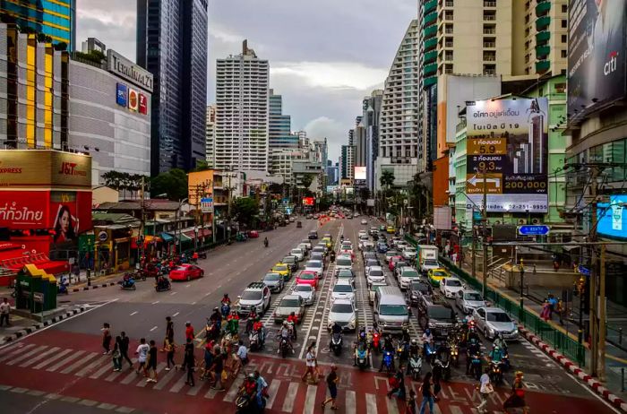 Crowds navigating a busy crosswalk in Bangkok