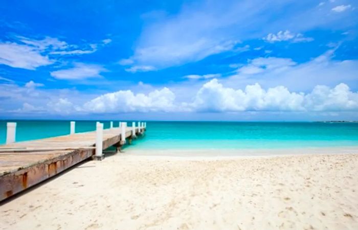 A charming wooden pier extending into the stunning Freeport Beach in the Bahamas.