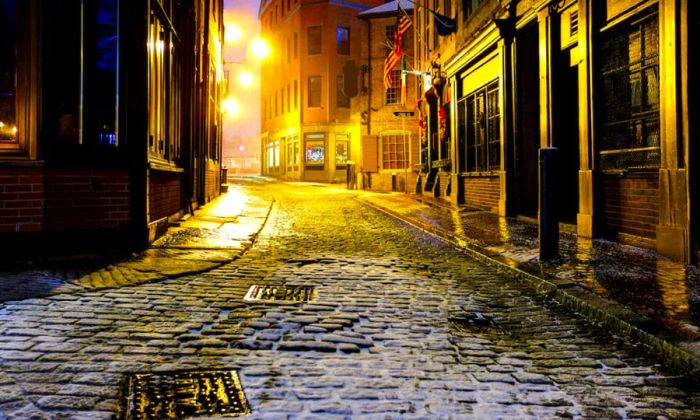 A dimly lit, snow-covered alley in Boston, Massachusetts.