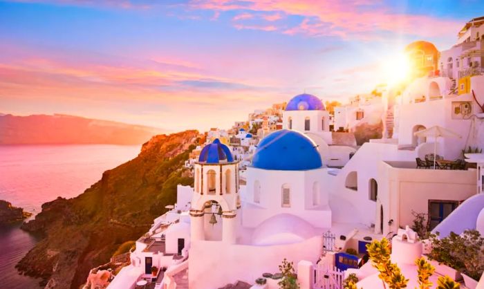 A sunset view of the blue-domed churches in Santorini, Greece.