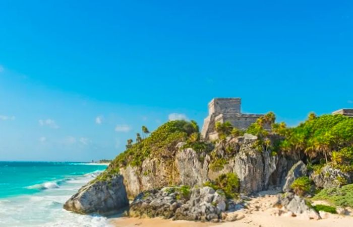 A side view of the Tulum pyramid set against the beach near Cozumel, Mexico