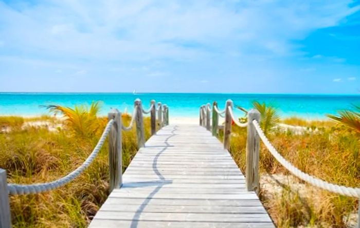 A picturesque wooden bridge spanning the lush grass at Mather Beach in Freeport, Bahamas.