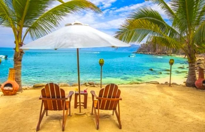 Beach chairs and an umbrella at the enchanting Las Caletas Beach Hideaway in Puerto Vallarta, Mexico