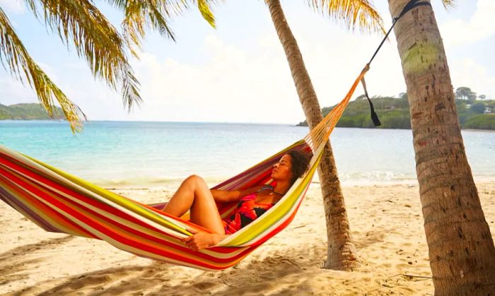 A woman lounging peacefully in a beach hammock