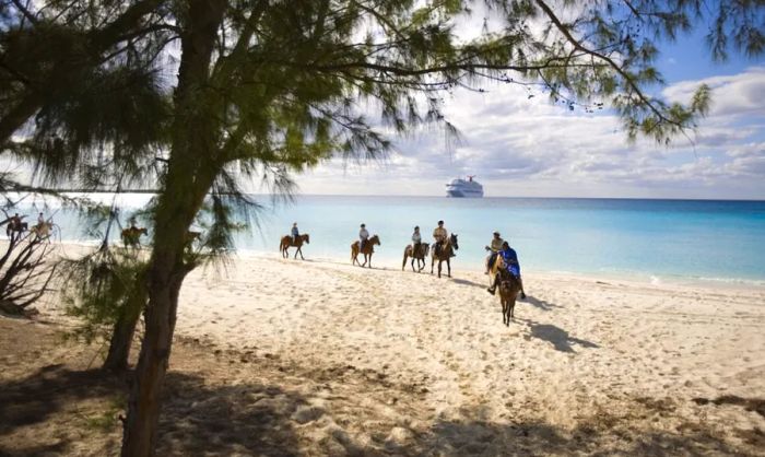 Group horseback riding along the beaches of Half Moon Cay