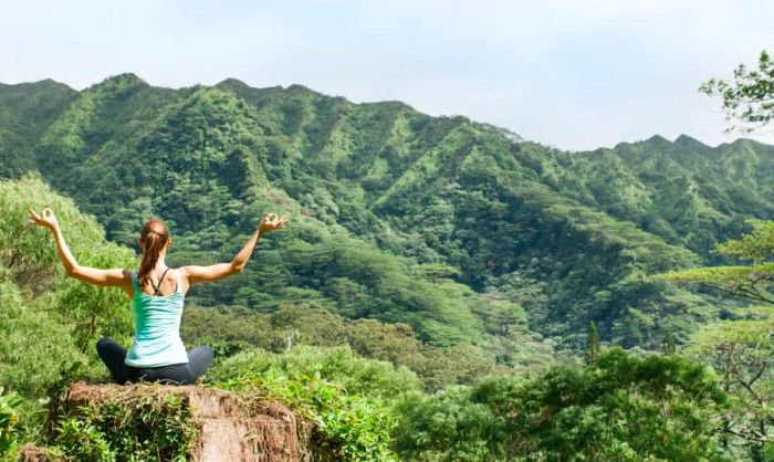 A woman meditating in a serene natural setting.