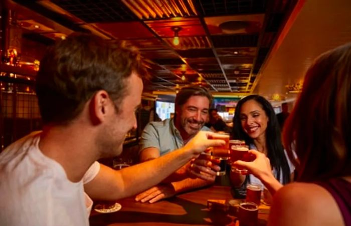 A group of friends enjoying beers at Guy’s Pig and Anchor Bar-B-Que Smokehouse and Brewhouse