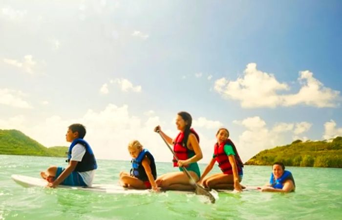 family enjoying paddleboarding in the Caribbean