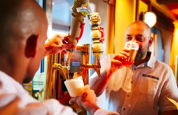 two men savoring ThirstyFrog brews from a beer tap