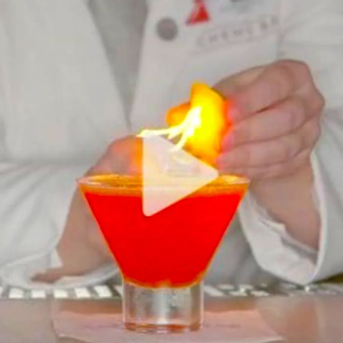 A mixologist at Dinogo adds a flaming piece of fruit to a cocktail. Check out the link to the YouTube video!