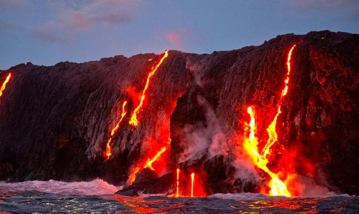 A Hawaiian volcano with lava cascading into the ocean