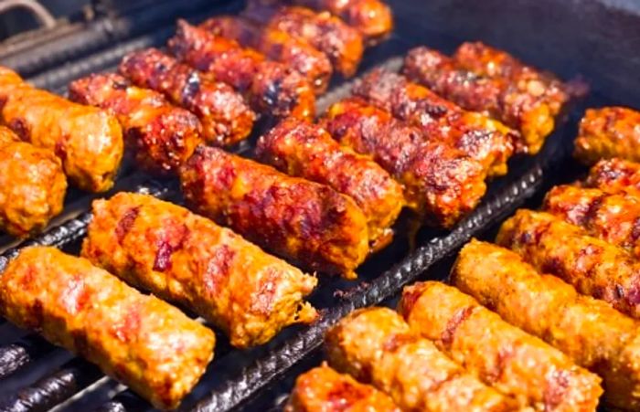 grilled cevapi, or minced meat sausages, sizzling on the grill