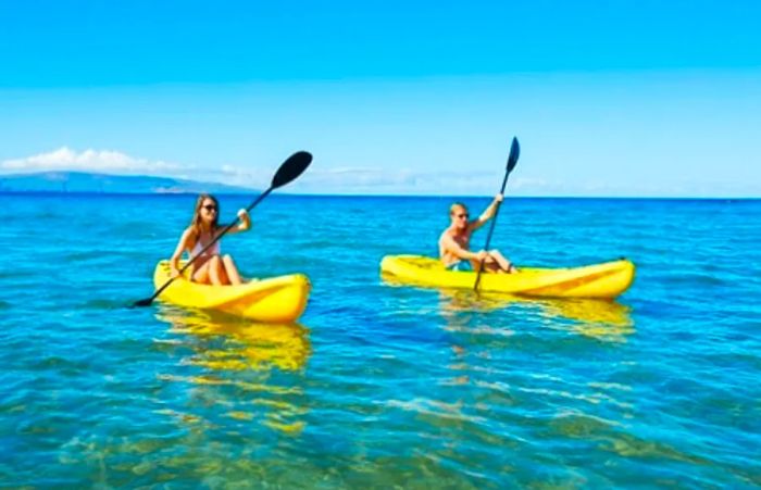 a couple kayaking in the ocean on vacation