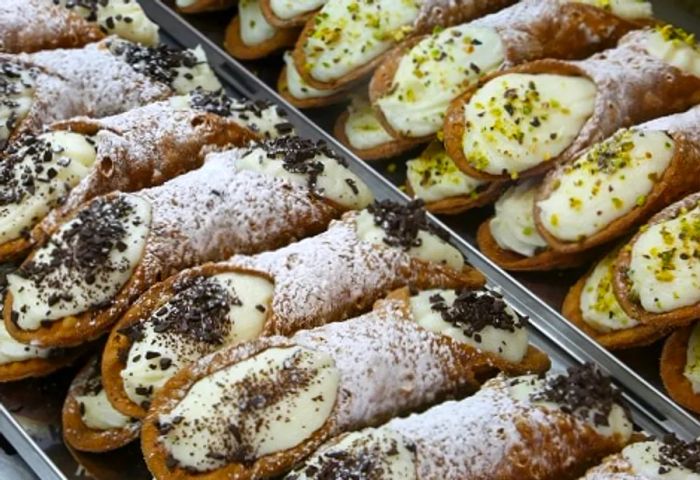 A showcase of cannoli in a Palermo bakery