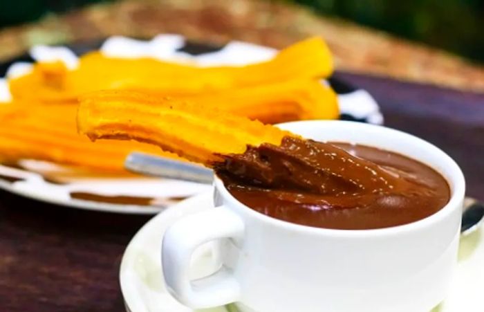 churros being dipped in hot chocolate