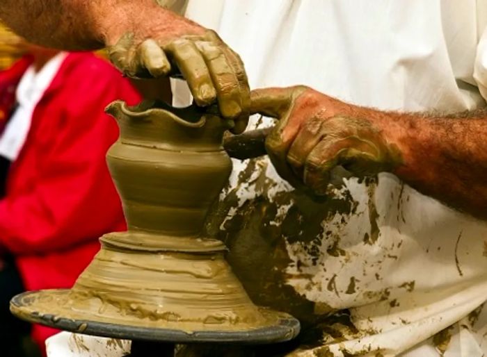 a Maltese pottery artist shaping a small vase