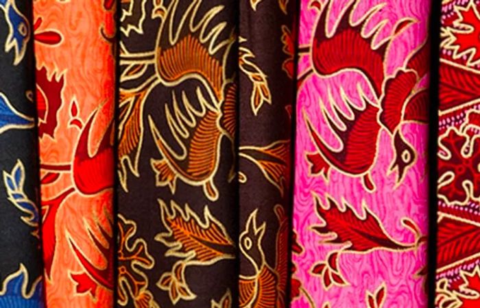 a variety of colorful batik fabrics featuring a bird design on display