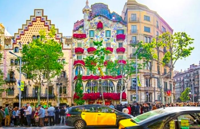 a panoramic view of Casa Batlló adorned with roses hanging from the balconies in Barcelona