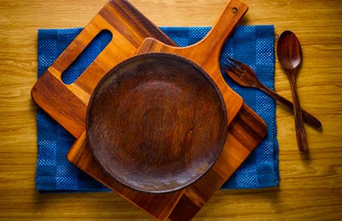 a stack of wooden kitchen utensils atop a blue fabric